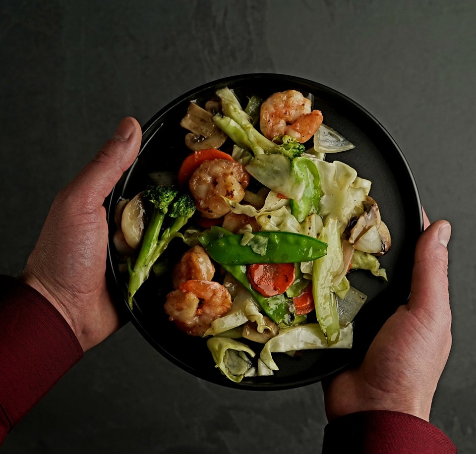 Shrimp and mixed vegetables served on a black plate