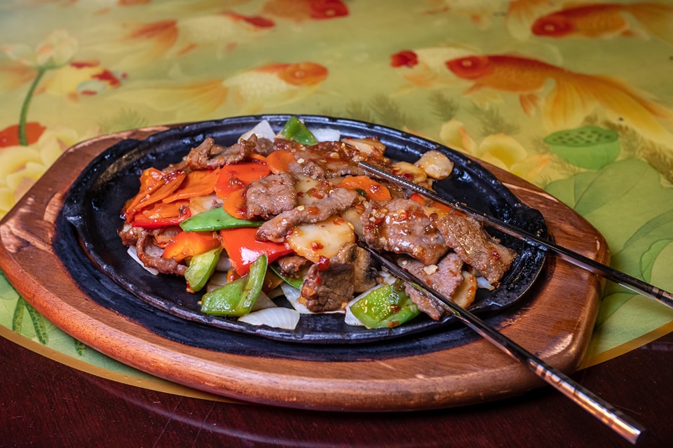 Sizzling beef and vegetables served on a hot platter